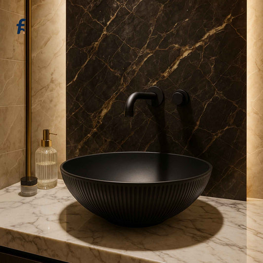 Black sink on a marble countertop with a textured wall in the background