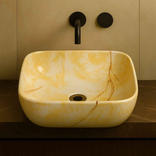 Oval-shaped marble washbasin with golden beige veining placed on a luxury bathroom counter, front view.