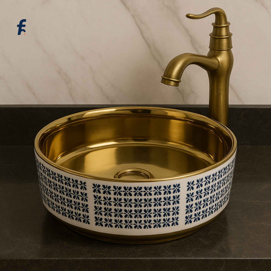 Gold sink with decorative patterns and matching faucet on a marble background