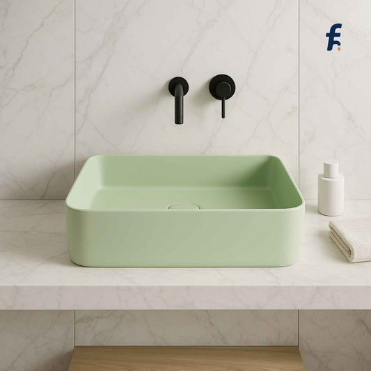 Green sink with black faucet in a bathroom setting, Close-up front view of soft mint green wash basin.