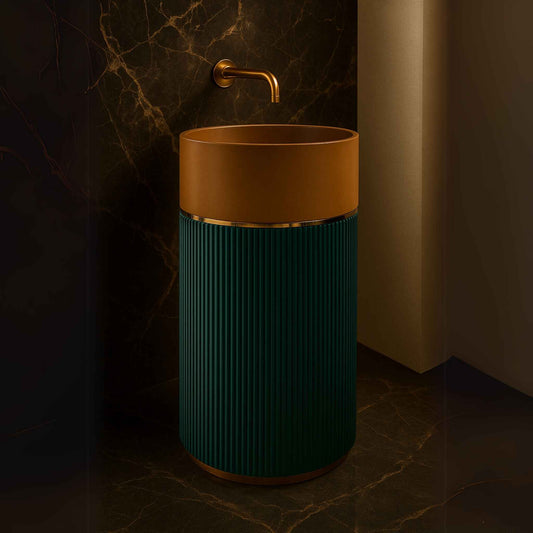 Cylindrical pedestal washbasin with terracotta top, teal fluted base, and brass wall-mounted faucet in luxury bathroom front angle