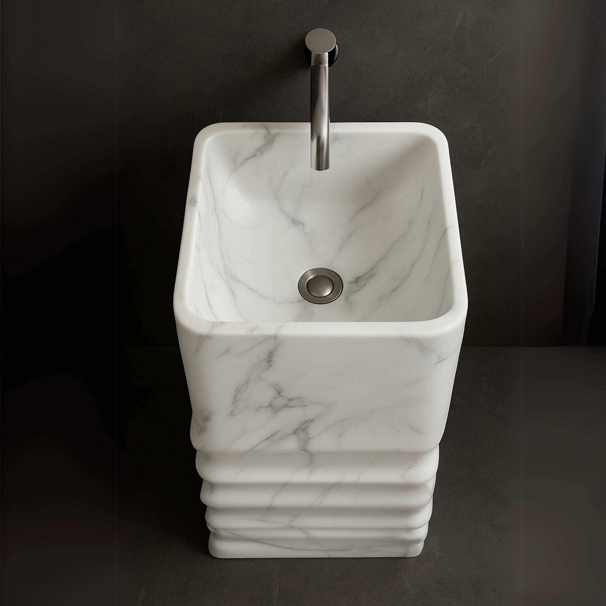 Top-down view of marble pedestal basin showing inner bowl and gray veining with chrome faucet