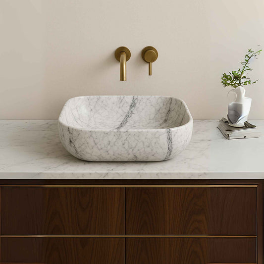 Side view of white marble bathroom sink placed on a designer vanity