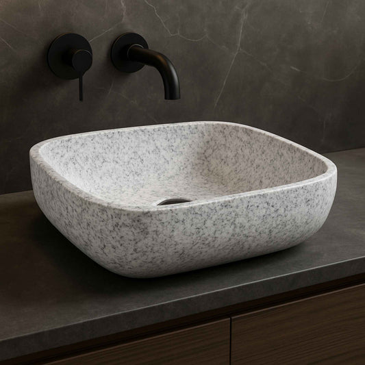 Front view of rectangular white speckled granite bathroom wash basin on dark marble vanity